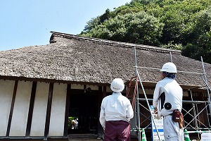 茅葺屋根の修繕工事をしている様子の写真