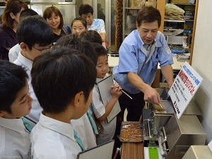 機械の前で説明を受ける様子