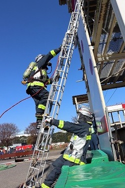 消防隊員が梯子で2階へ上がる様子